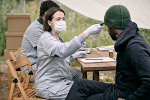 Man getting temperature checked at a free outdoor clinic 