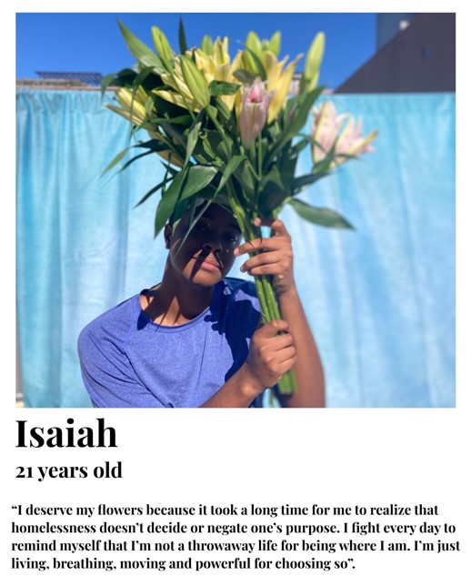 Isaiah holding flowers in front of his face. I deserve my flowers because it took a long time for me to realize that homelessness doesn't decide or negate one's purpose.